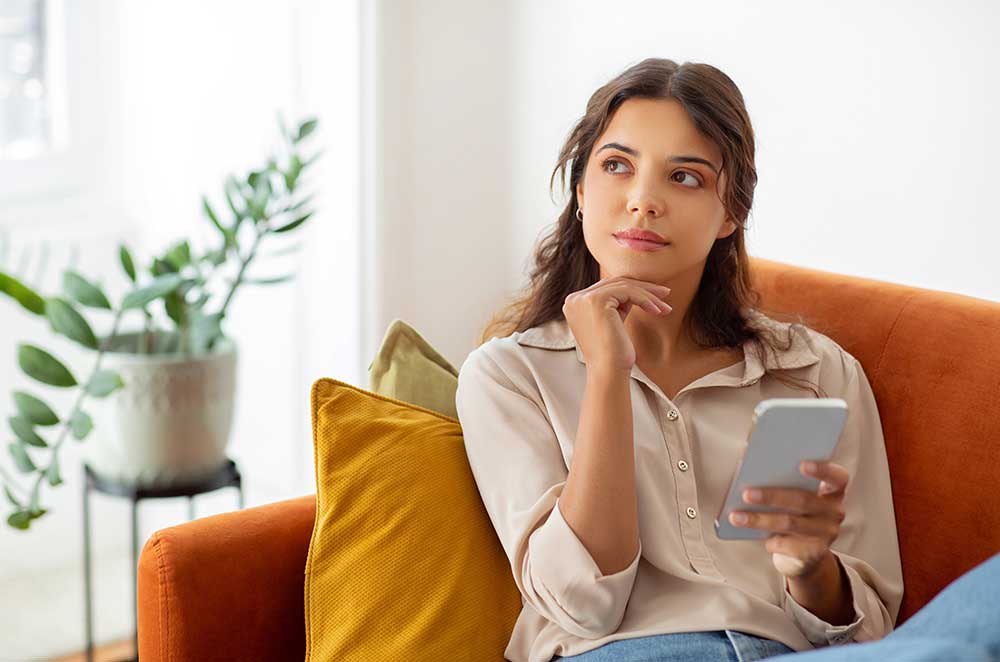 woman-thinking-holding-phone